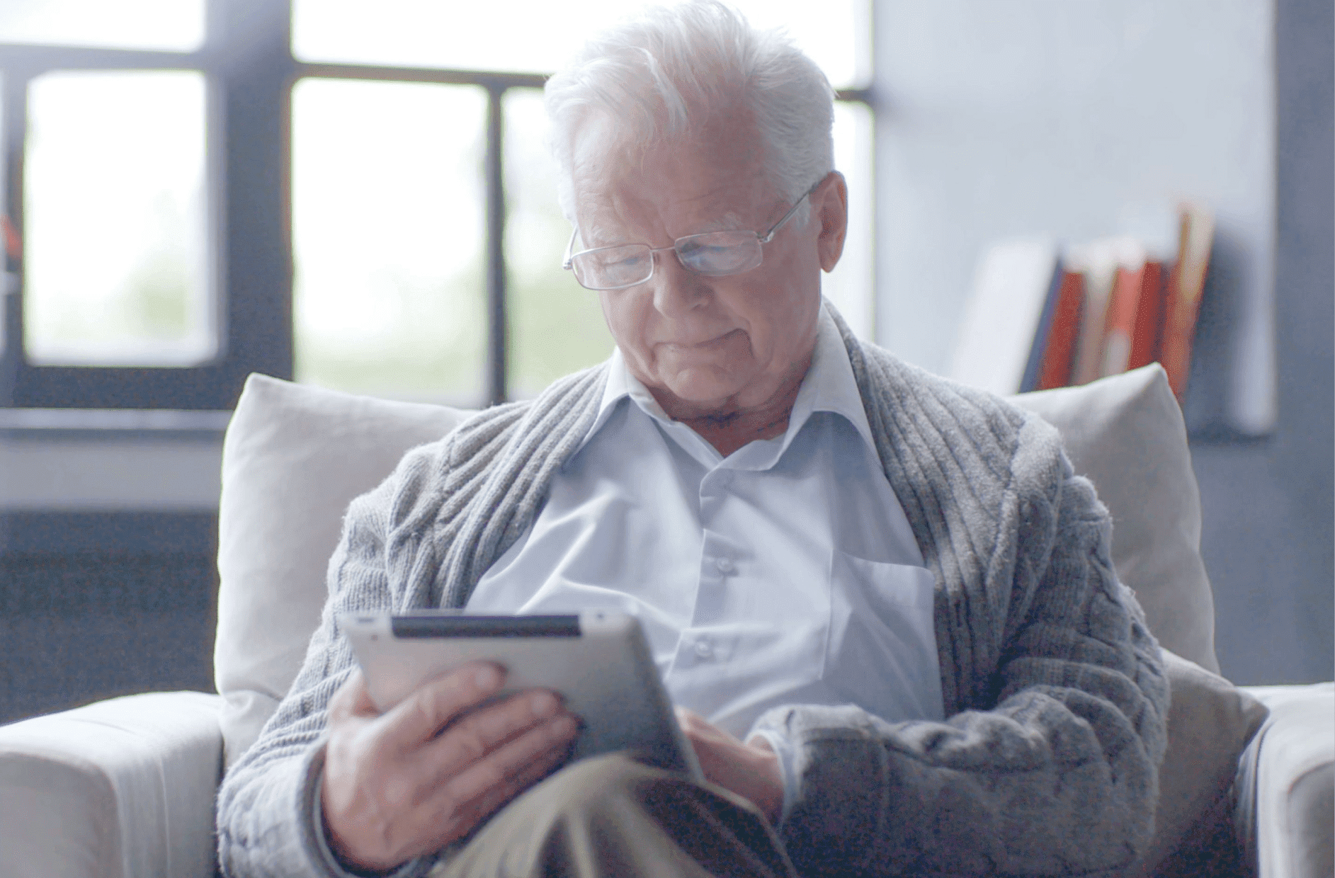anziano su divano con tablet